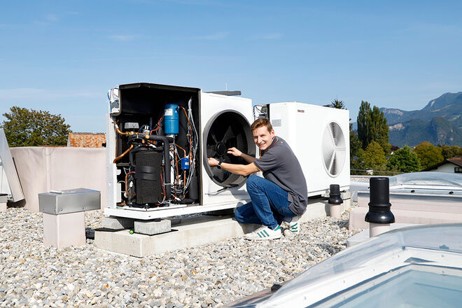Ein Techniker arbeitet auf einem Dach an einer Wärmepumpe, umgeben von Bergen und blauem Himmel.
Servicemonteur repariert Wärmepumpe